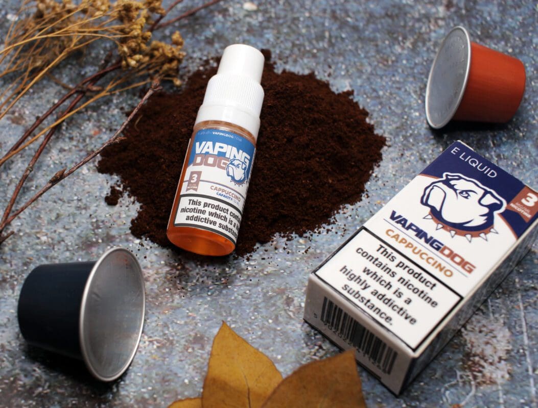 Vaping Dog Cappuccino - graphic - eliquid placed on ground coffee, featuring coffee pods and organic dried plants